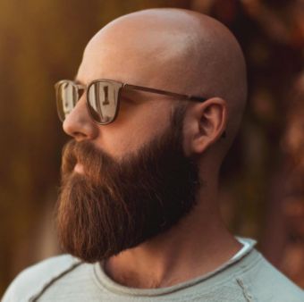 homem careca de barba lenhador e óculos